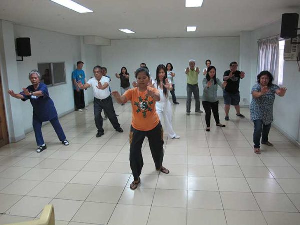 A Tai chi chuan class I was teaching in 2013. Annie Sollestre is leading the group. Ed is the man to the right and behind Annie.