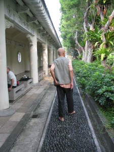 Man Walking Backward Barefoot on Stones